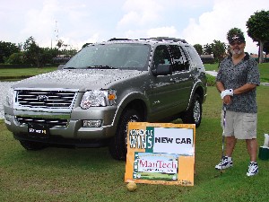 Miami: Mr. Jose Agosto, ManTech Facility Security Officer, stands next to the ManTech sponsored hol in one car